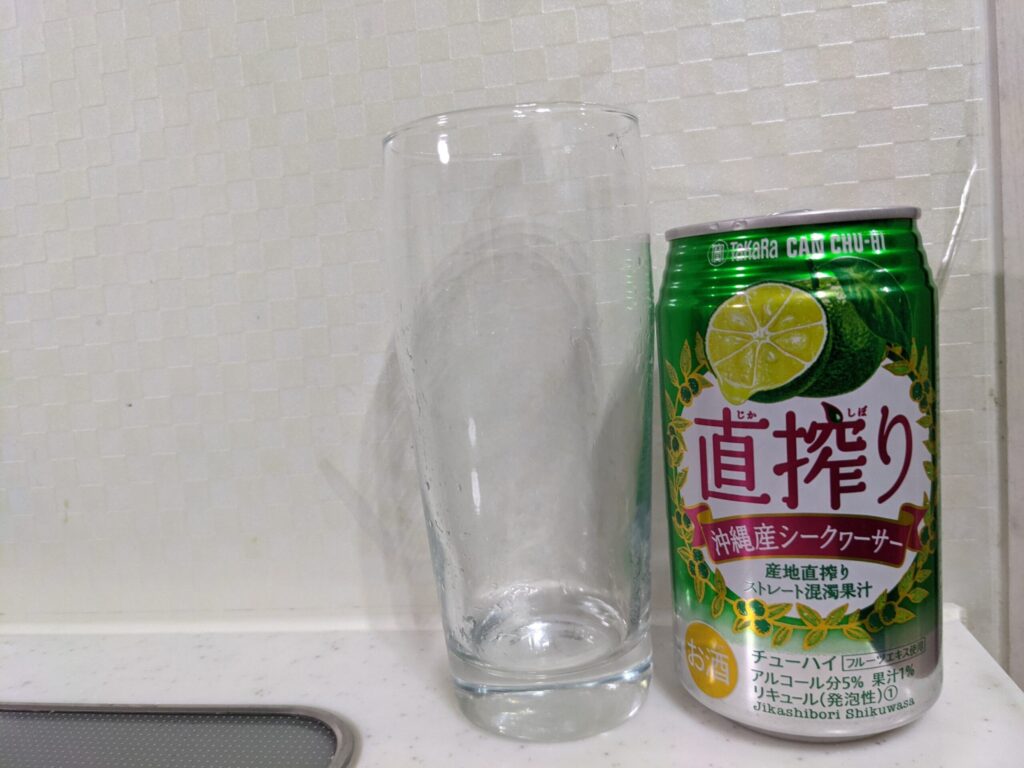 「直搾り沖縄産シークヮーサー」を飲み終えたグラスとその空き缶