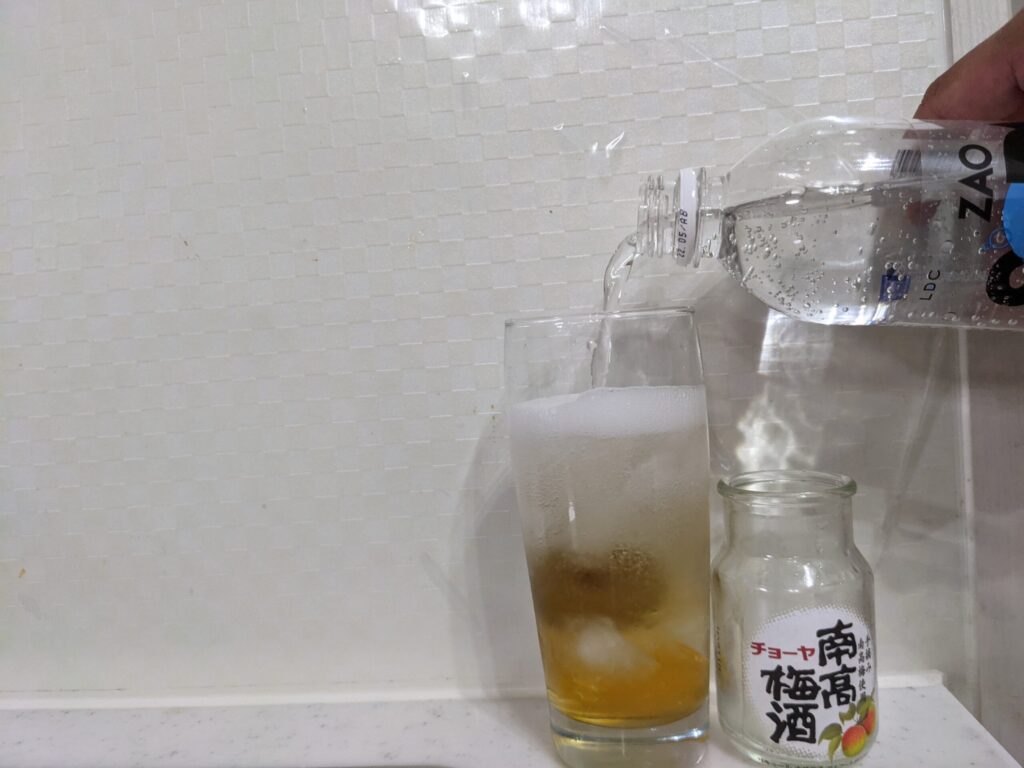 「チョーヤ南高梅酒（梅入り）95ml」が入ったグラスに炭酸水をグラス8割まで注いだところ