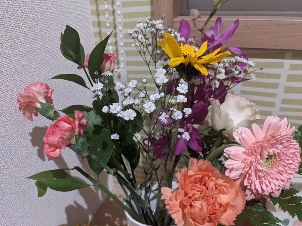 室内に置いた【ma fleur】マ・フルールで届いた花を入れた白い花瓶のアップ